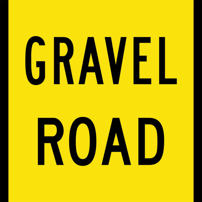 A yellow and black Gravel Road Sign