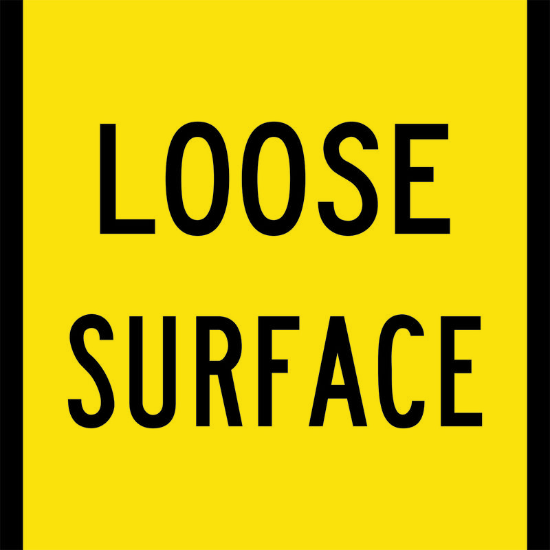 A yellow and black Loose Surface Sign