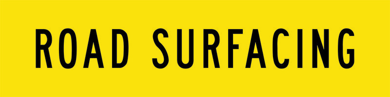 A yellow and black Road Surfacing Sign