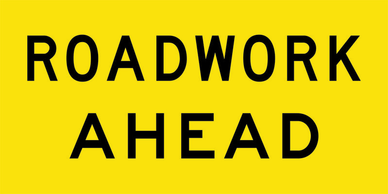 A yellow and black Roadwork Ahead Sign