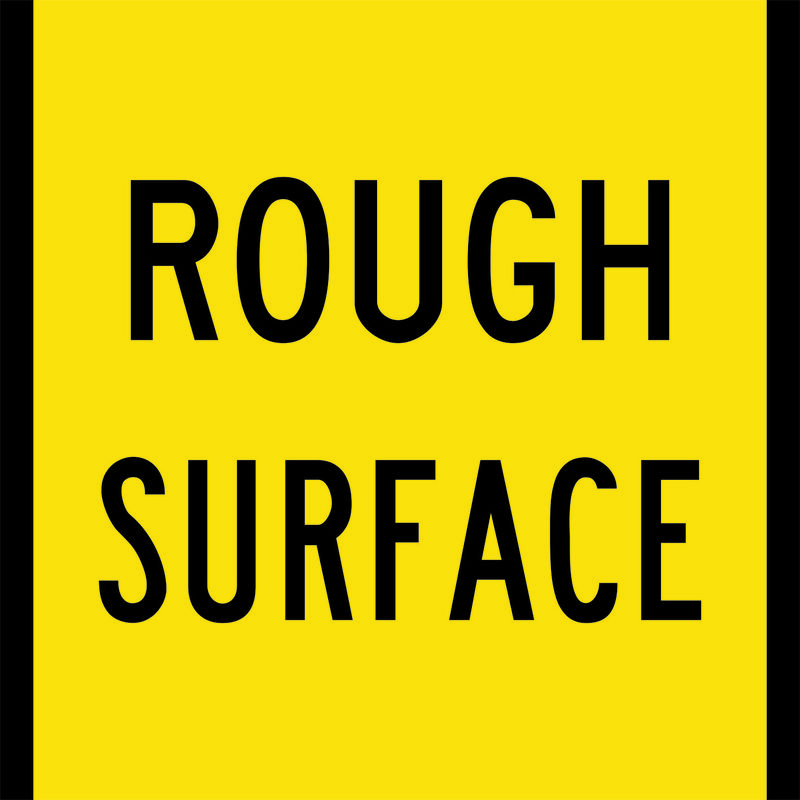 A yellow and black Rough Surface Sign