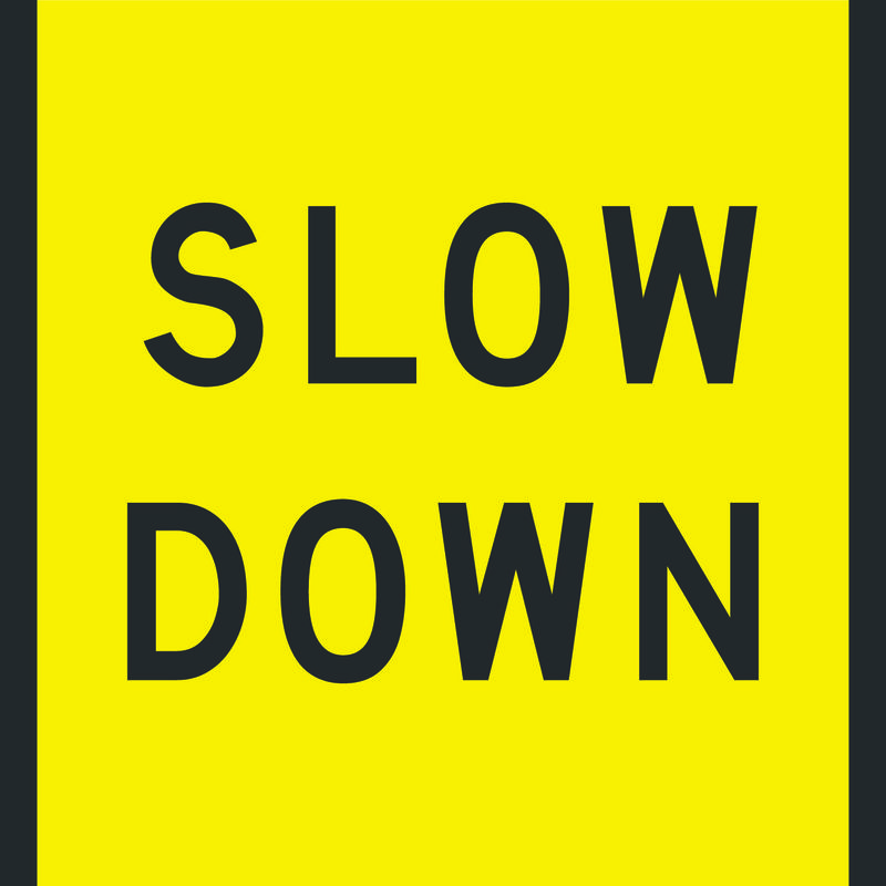 A yellow and black Slow Down Sign