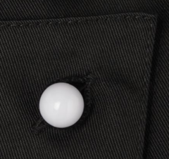 A single white Chef+39s Button on black fabric