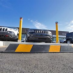 A yellow and black Rubber Wheel Stop in a carpark